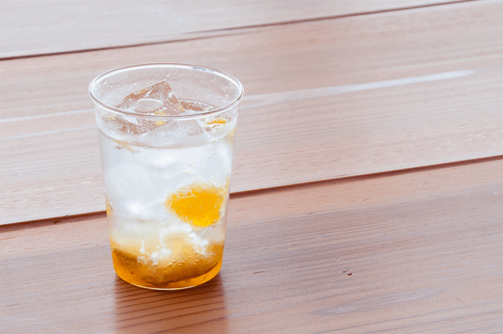 果実と米麹の発酵ドリンク(夏にぴったりの爽やか発酵飲料) 氷が入った透明なカップに注がれた果実と米麹の発酵ドリンク